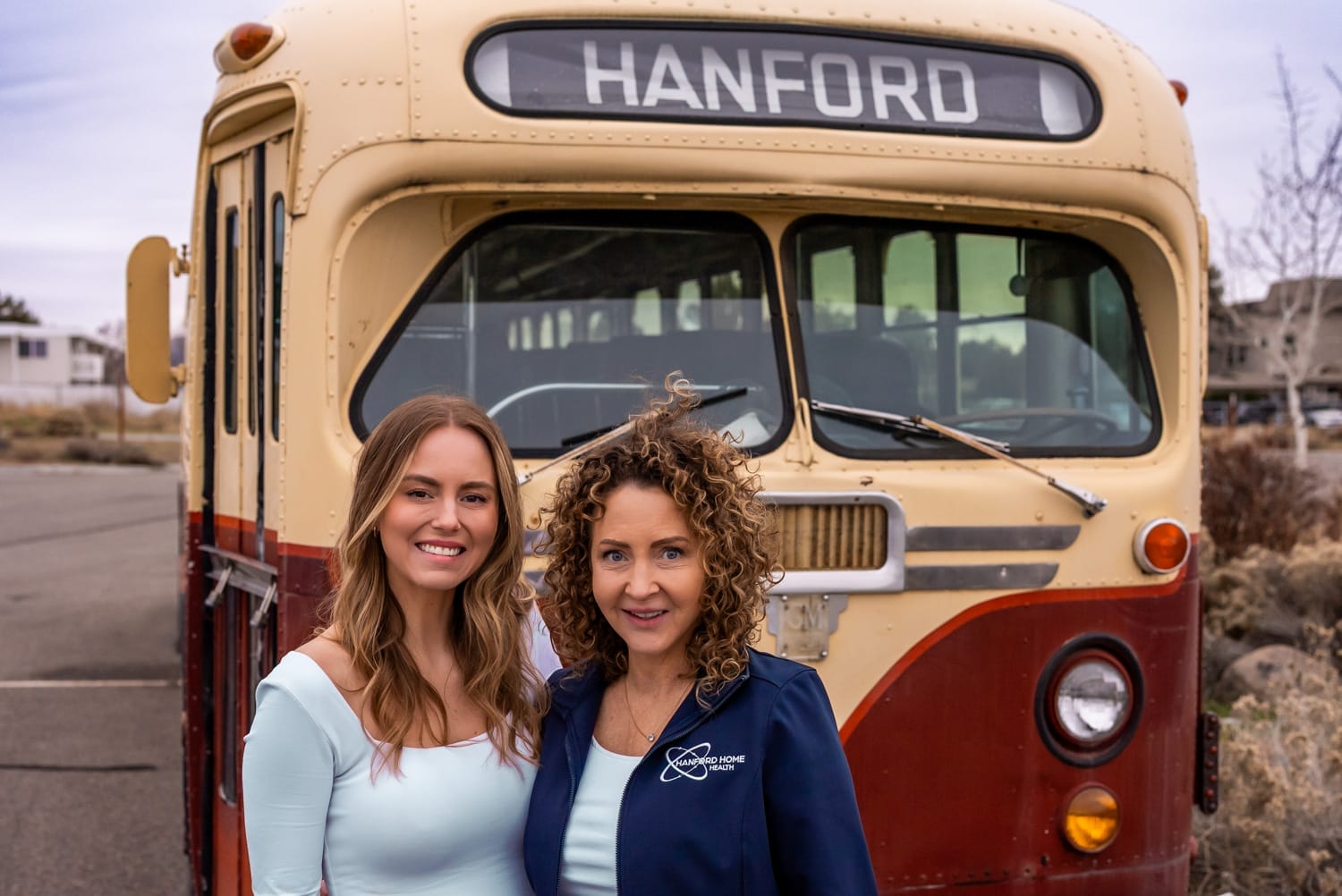 owners of Hanford Home Health standing in front of the Hanford bus